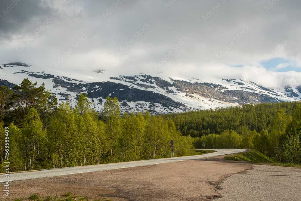 Fototapeta premium Asphalt road in the snowy Norwegian mountains