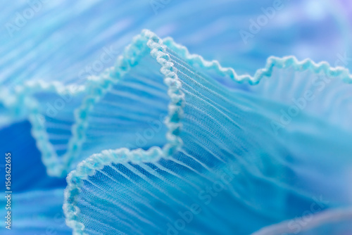 Close-Up of Light Blue Translucent Fabric with Pleated and Ruffled Edges – Delicate Wavy Texture for Fashion, Textile Design, Branding, and Elegant Visual Concepts