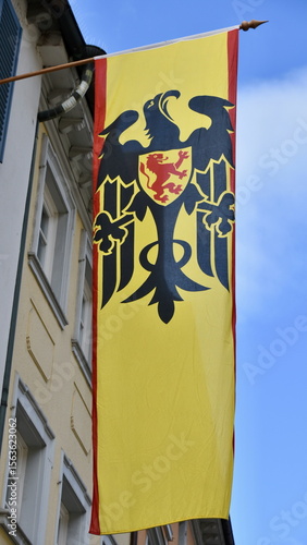 Flag of the City of Überlingen, Germany with Building Facade and Blue Sky