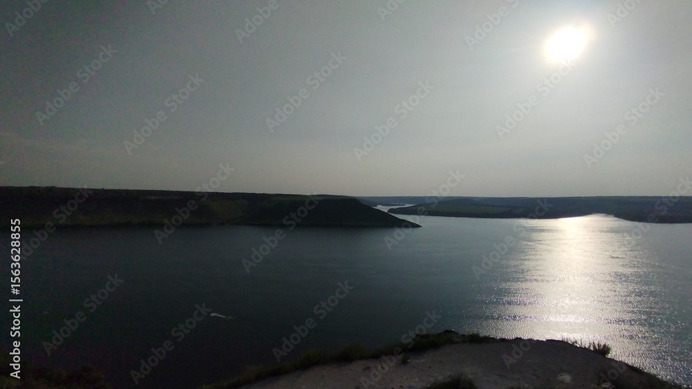 Fototapeta premium Panoramic View of River and Green Cliffs under Clear Sky