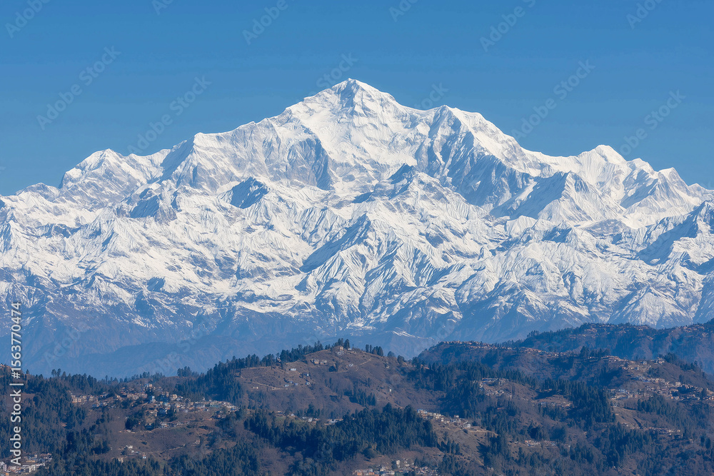 Fototapeta premium a mountain range with a river running through it and snow capped mountains in the background, with a blue sky