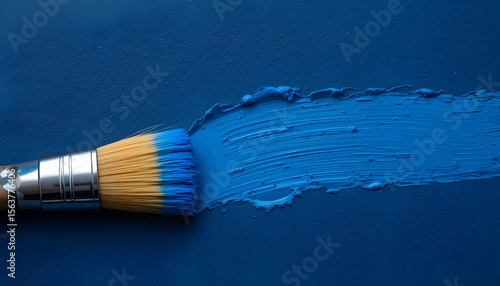 Close-Up Photo of Paintbrush and Blue Paint Stroke on Dark Textured Surface