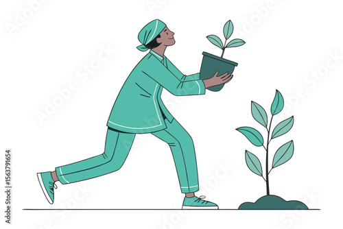 A person in teal scrubs and headscarf carefully carries a potted plant towards a newly planted sapling