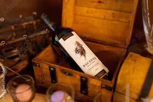 Fotografía A bottle of wine elegantly placed inside a decorative chest, creating a luxurious and vintage-inspired presentation
