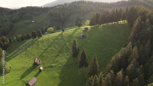 Aerial view of the Transylvanian village in the mountains, during summer. Sunset scene over the mountain valley in the Carpathian Mountains