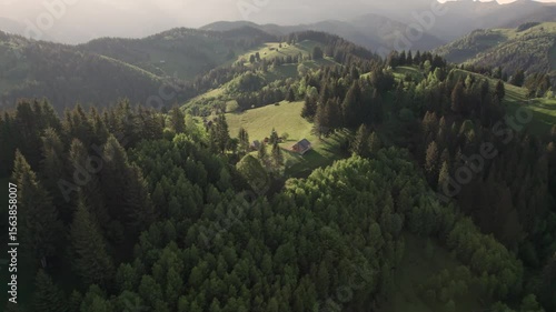 Aerial view of the Transylvanian village in the mountains, during summer. Sunset scene over the mountain valley in the Carpathian Mountains