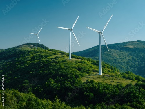 Three white wind turbines stand tall on a lush green rolling hillside under a clear blue sky