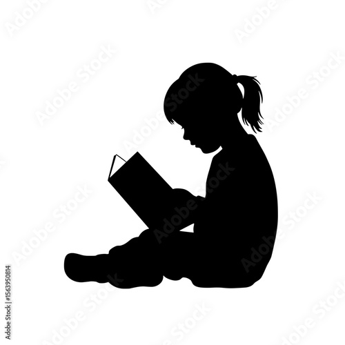 Silhouette of child reading a book while sitting on the floor  
