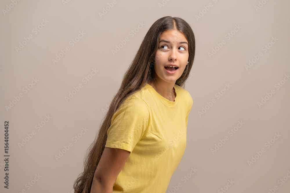 Obraz premium Surprised young woman with a guilty expression as if caught eavesdropping.