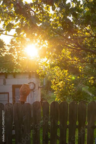  Clay pot on a wooden fence at sunset. Captures the cozy charm of rural life 
