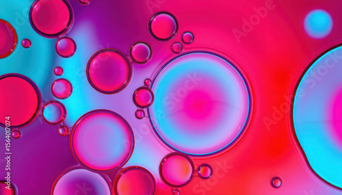 Abstract vibrant pink and blue oil bubbles floating on water surface.