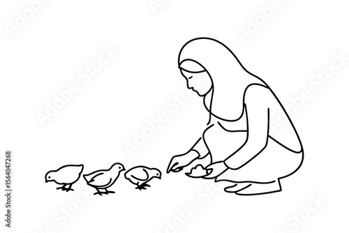 Woman feeding chicks poultry farm