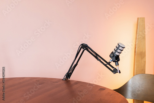 High-quality microphone setup on a wooden table ready for a podcast recording session in a cozy studio