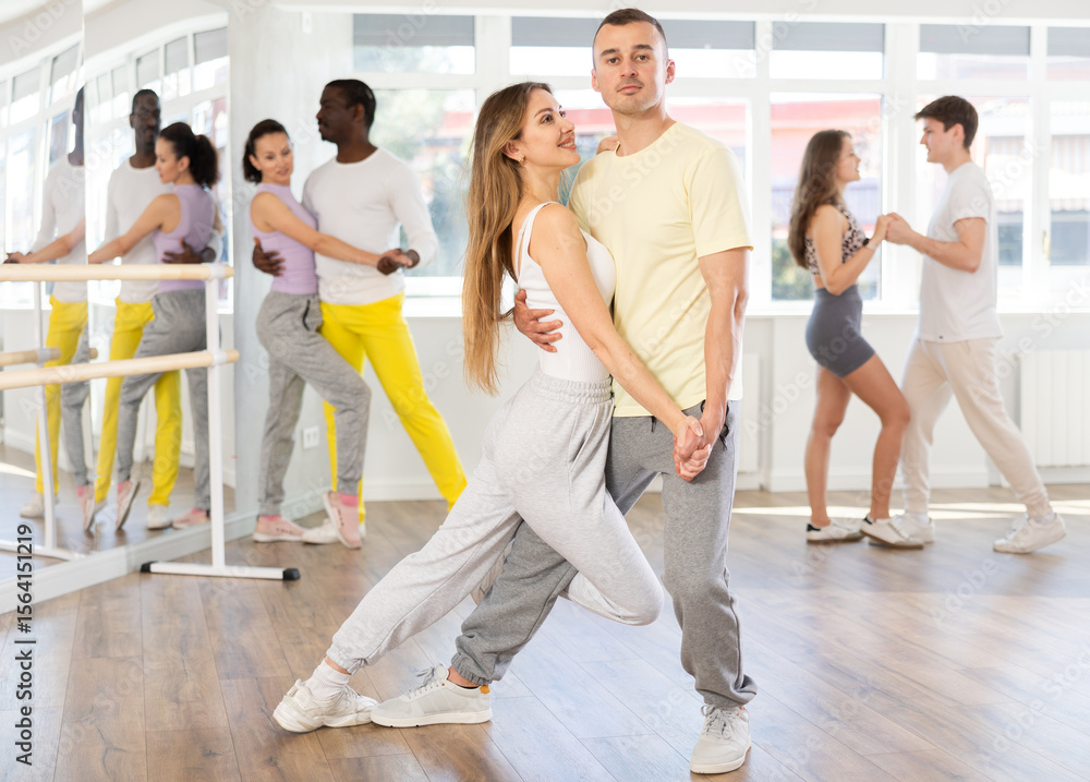 Fototapeta premium Young man and young woman dance couple latin dances in studio..