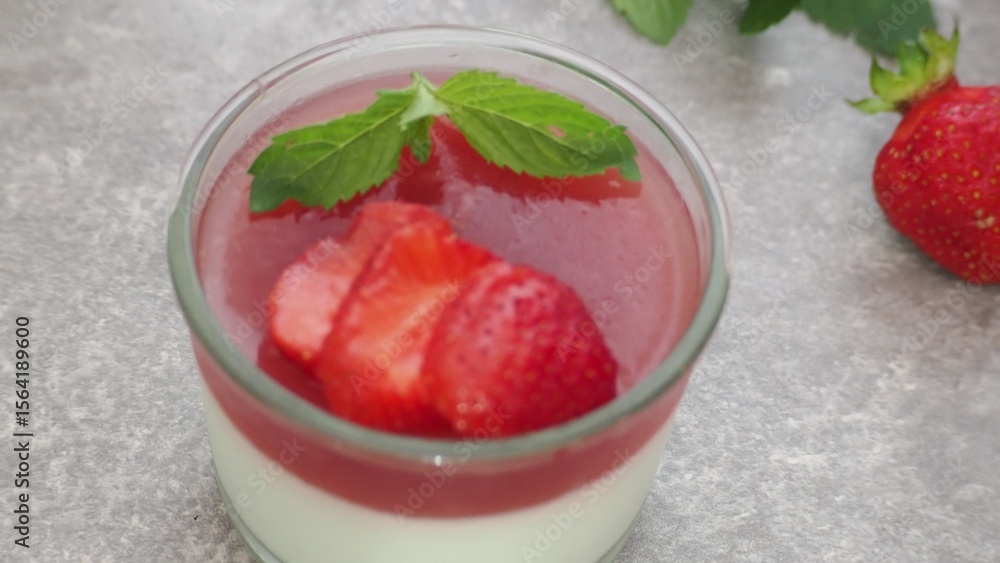Vanilla panna cotta with strawberry layer in a small portioned vase and fruit pieces in wineglasses. Delicious Italian dessert. low calorie dessert healthy eating diet. woman cooking at home Vanilla panna cotta with strawberry layer in a small portioned vase and fruit pieces in wineglasses. Delicious Italian dessert. low calorie dessert healthy eating diet. woman cooking at home