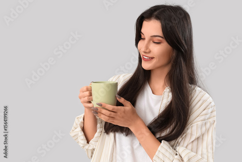 Pretty young woman with cup...