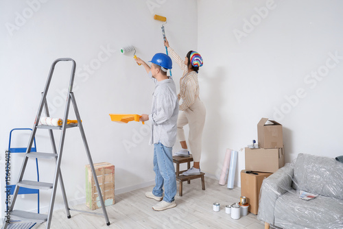 Young couple painting wall ...