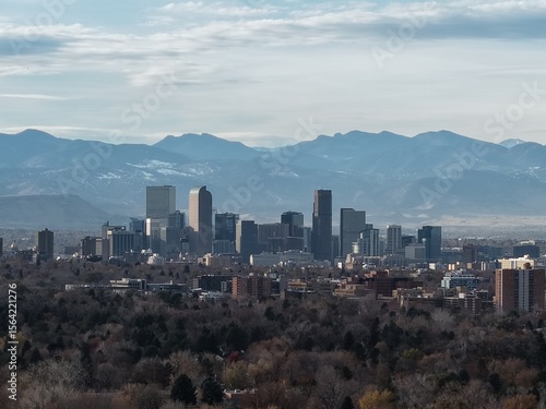Canvas Print Iconic Denver skyline framed by the majestic, hazy Rocky Mountains under a cloudy sky