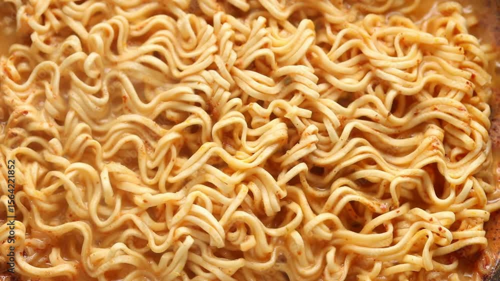 Close-up cooking shot of instant noodles boiling in spicy soup. Top view shot Close-up cooking shot of instant noodles boiling in spicy soup. Top view shot