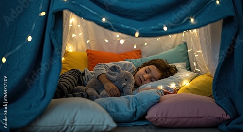 Child sleeping in a cozy blanket fort