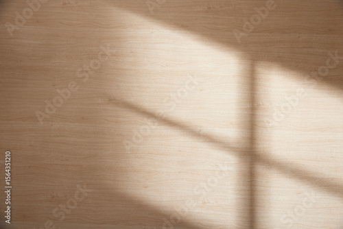 Wood texture background with natural shadows and silhouettes of leaves from natural light streaming through a window.