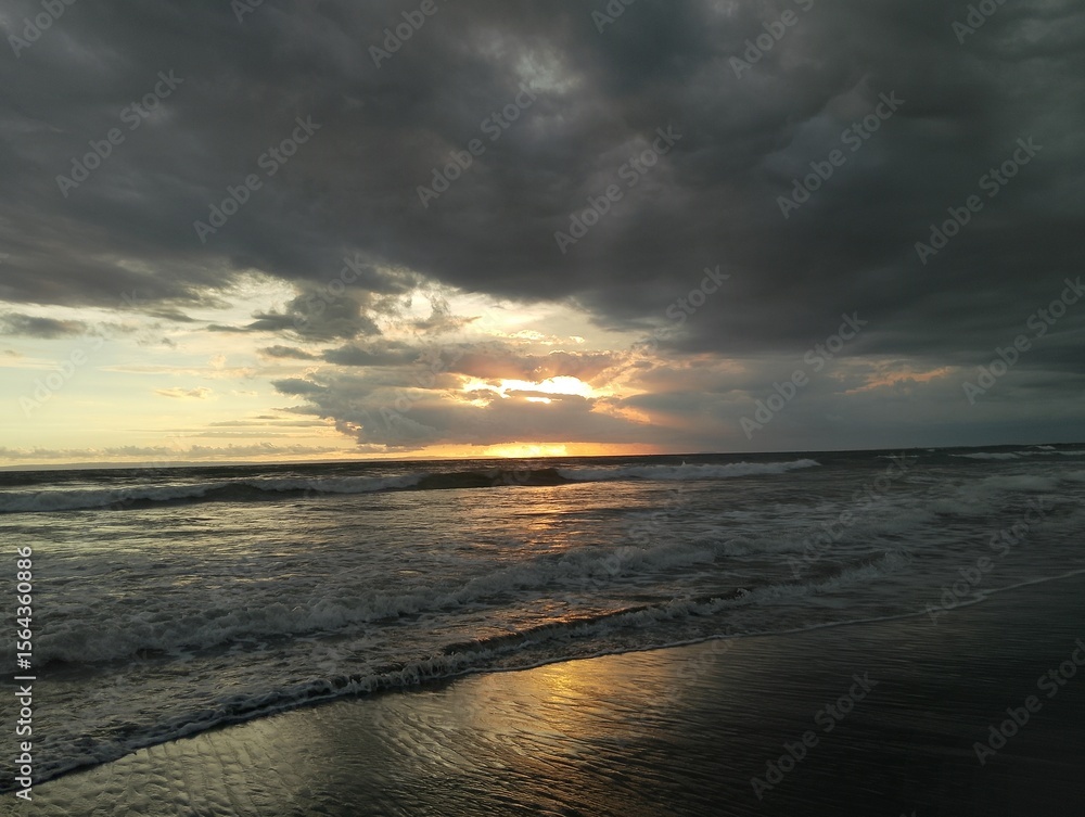 Obraz premium Beautiful landscape photography on the beach at golden hour sunset. Dramatic sea sunset with reflection of sunlight over water surface.