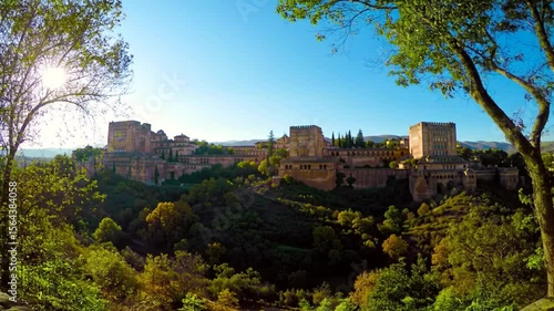 Beautiful Alhambra Palace in Granada Spain framed by lush green trees at sunrise