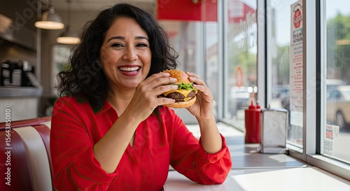 Woman eating a cheeseburger in a diner