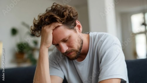 Reflection of Despair: A man with a weary expression, head in hand, embodies the weight of internal struggles, capturing the raw essence of emotional distress. 