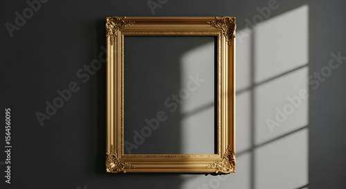 Ornate gold picture frame against a dark wall, illuminated by sunlight streaming through a window.