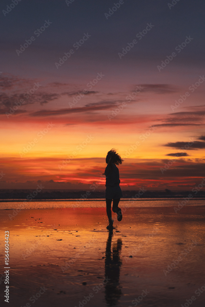 Silhouette of woman dancing joyfully on tropical beach at sunset Silhouette of woman dancing joyfully on tropical beach at sunset