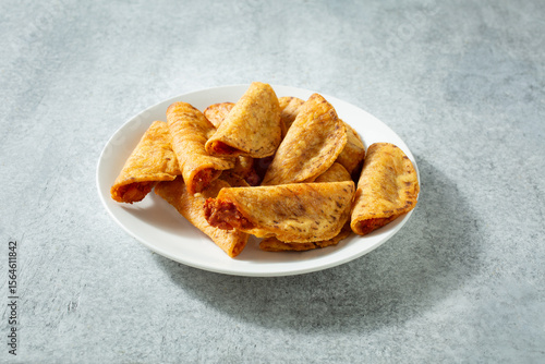 A view of a pile of mini tacos, on a plate.