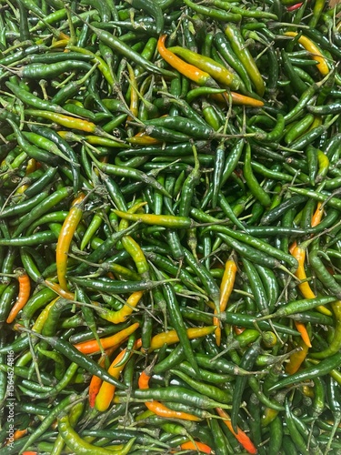 close up of green small chillies at the market