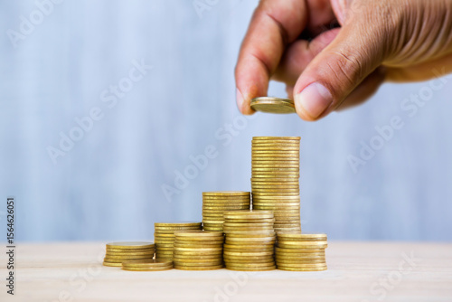 Фотография Hand stacking coins, symbolizing growth, saving, or investment
