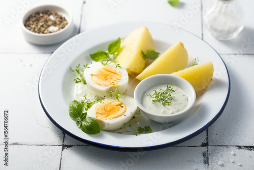Hard boiled eggs with potato and green sauce