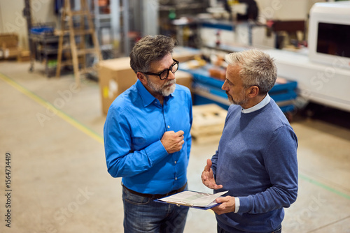 Professional Discussion Between Two Colleagues in a Business Casual Office Environment
