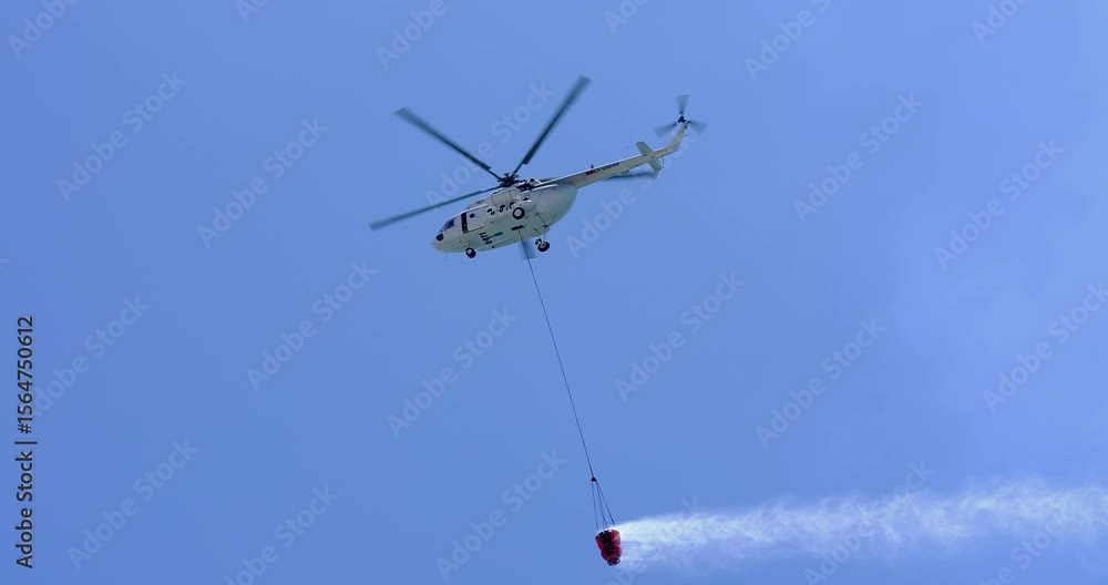 A firefighting helicopter carrying water to a forest fire A firefighting helicopter carrying water to a forest fire