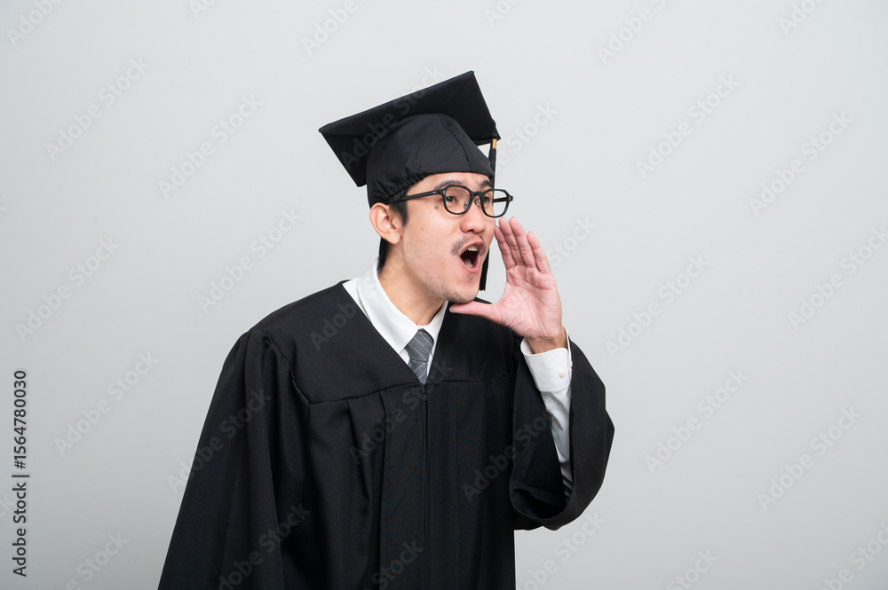 A young man in a graduation gown and cap smiles at the camera, striking a confident pose to celebrate his academic achievement on graduation day. A young man in a graduation gown and cap smiles at the camera, striking a confident pose to celebrate his academic achievement on graduation day.
