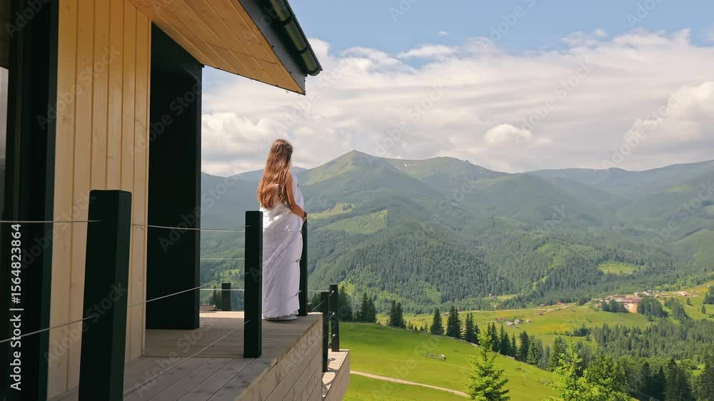 Woman in Blanket Enjoying Mountain Landscape, Standing on Wooden Terrace Facing Scenic Carpathian Peaks Woman in Blanket Enjoying Mountain Landscape, Standing on Wooden Terrace Facing Scenic Carpathian Peaks