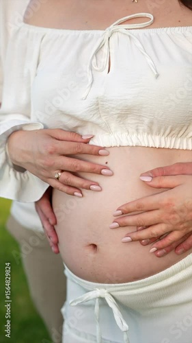 Wallpaper Mural A pregnant girl and a man are standing on the street and hugging.
Pregnant mother.
Gender party.
Love and relationships.
Childbirth.
Pregnant girl's belly in a man's arms. Torontodigital.ca