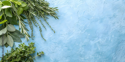 Botanical arrangement featuring rosemary, eucalyptus and herbs on weathered blue stone surface with organic composition and shadows.