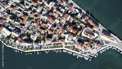Aerial view of a peninsula with tightly packed buildings and boats dotting the coastline, a vibrant contrast against the deep blue sea, Vranjic, Split-Dalmatia County, Croatia.