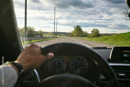 A person driving on a scenic, open road with a clear sky and lush greenery. Black Forest, Germany