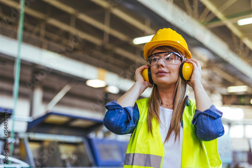 Fotografija Female Worker in Safety Gear at an Industrial Factory Setting