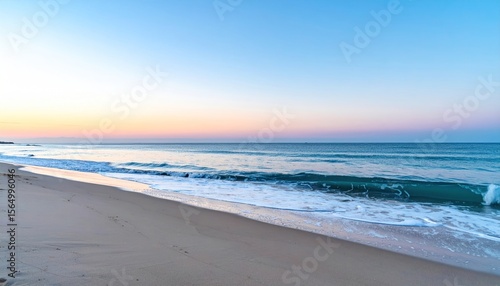 Peaceful beach scene at dawn with gentle waves under a pastel-colored sky