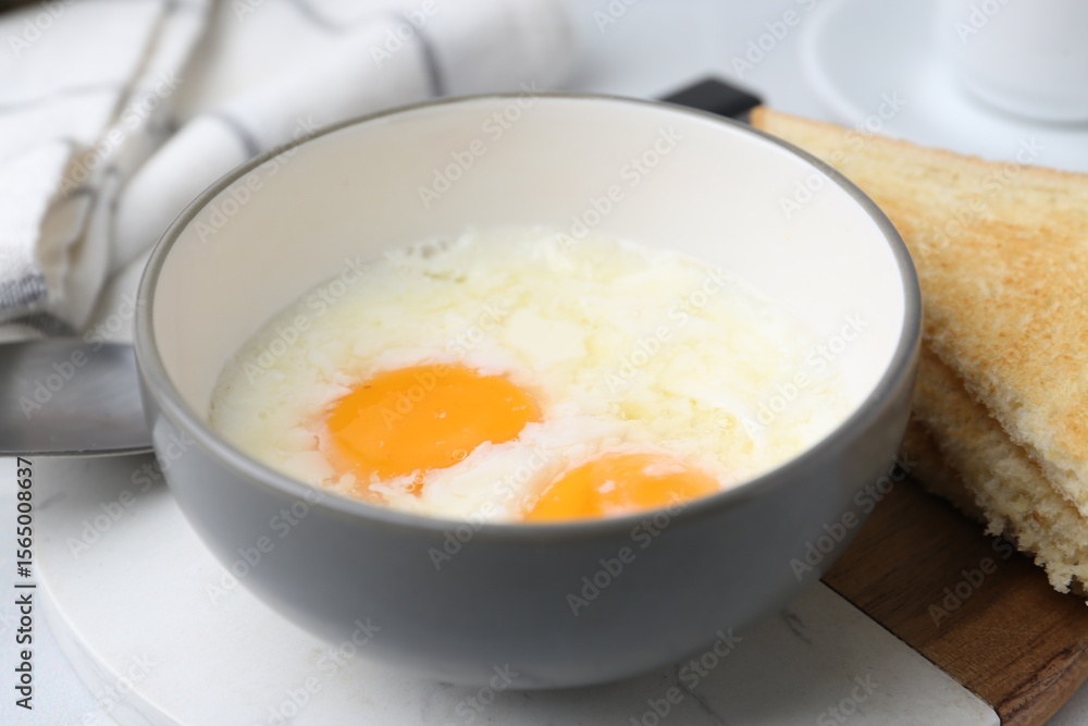 Half-boiled eggs in bowl and toasted bread on white tiled table, closeup. Traditional asian breakfast Half-boiled eggs in bowl and toasted bread on white tiled table, closeup. Traditional asian breakfast