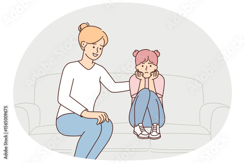 Mother stroking upset daughter on back sitting on couch after quarrel or important conversation