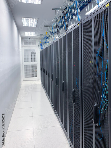 Modern IT server room with rows of black server racks in a high-tech data center environment, showcasing advanced technology, cyber security, and digital infrastructure.