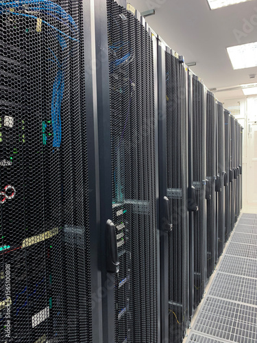 Modern IT server room with rows of black server racks in a high-tech data center environment, showcasing advanced technology, cyber security, and digital infrastructure.