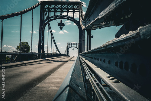 Perspective view of a historic metal bridge with symmetrical design under a blue sky, Kaiser Wilhelm Bridge in 26382 Wilhelmshaven, Germany
